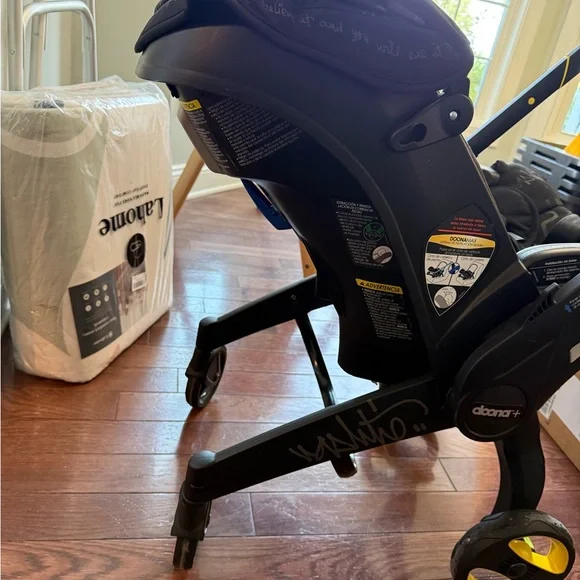 Doona Infant Car Seat & Stroller in Black with Yellow Accents - Picture 4 of 9